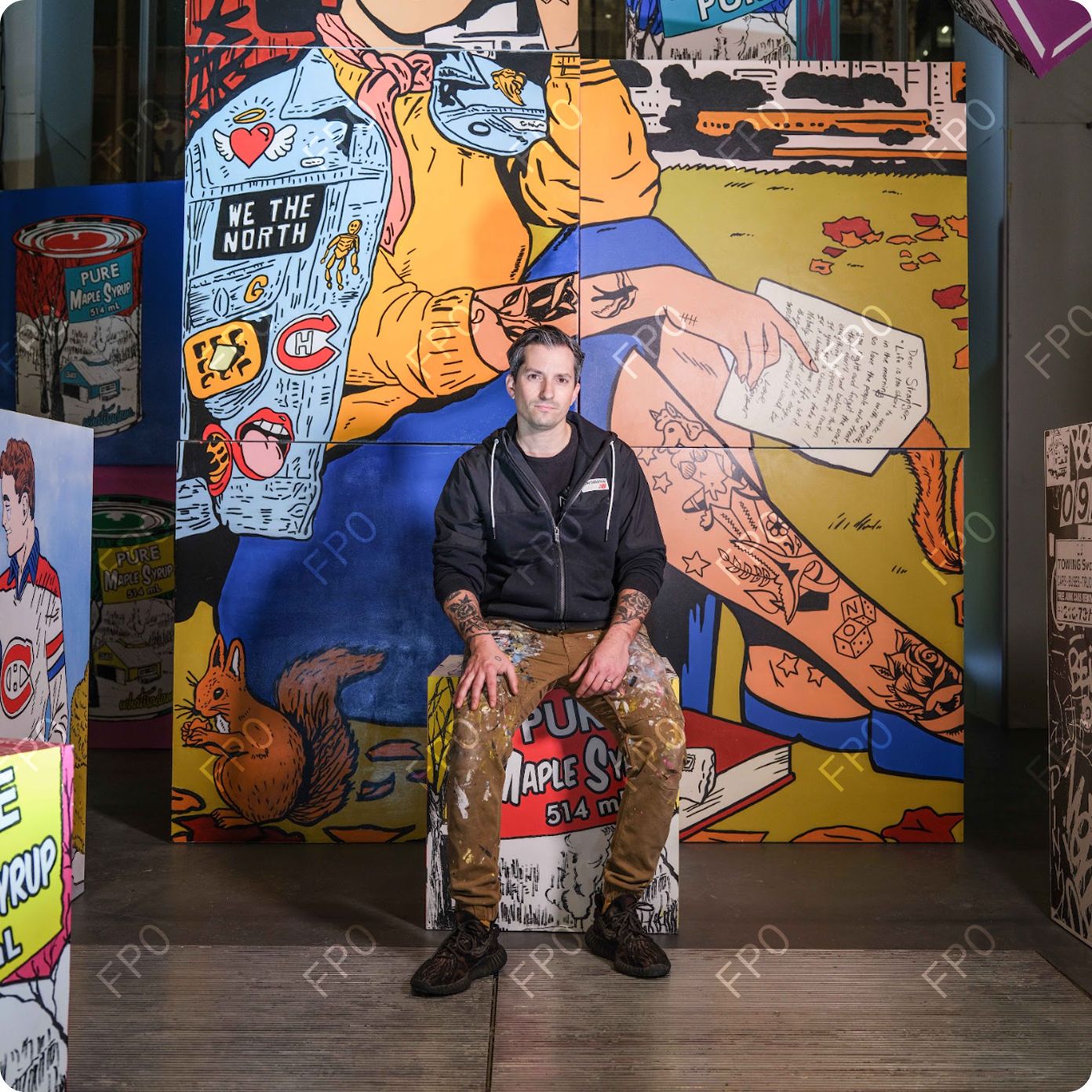 A man sitting on a chair in front of a mural